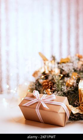 Dekorative Weihnachtsbäume und Geschenkboxen auf Holztisch gegen verwischtes Licht Stockfoto