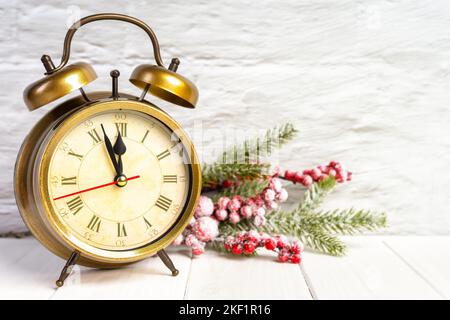 Dekorativer Weihnachtsbaum und Bronze-Wecker Countdown bis Mitternacht auf weißem Holz Hintergrund. Neujahrskonzept. Banner, Kopfzeile, Grußkarte, Zoll Stockfoto