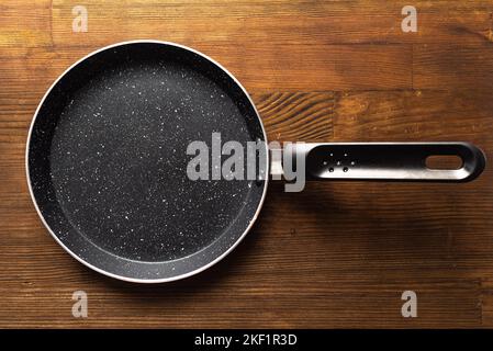 Leere Pfanne für Pfannkuchen auf Holzhintergrund Stockfoto