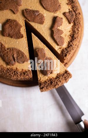 Kuchen mit Schnittstück und Klinge auf grauem Hintergrund, Nahaufnahme Stockfoto