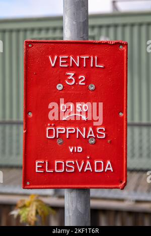 Ventil - öppnas vid eldsvåda. Marktschild oder Schild für rote Hydranten im Stadtteil Djugården in Stockholm, Schweden. Stockfoto