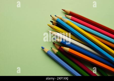 Ein Satz Buntstifte auf einem grünen Tisch. Stockfoto