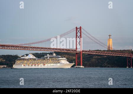 Das Oceania Cruises MS Marina Cruise Ship fährt unter der Brücke Ponte 25 de Abril und Santuário de Cristo Rei am Fluss Tejo, Lissabon, Portugal. Stockfoto