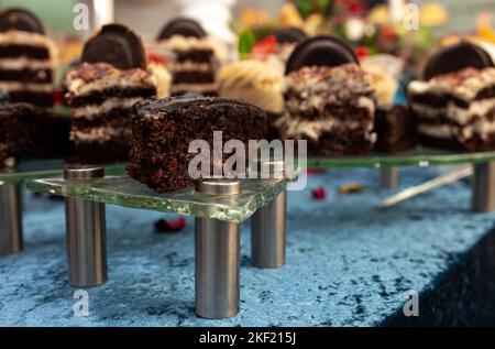 Frischer Schokoladen-Biskuit mit Creme auf einem Glasständer Stockfoto