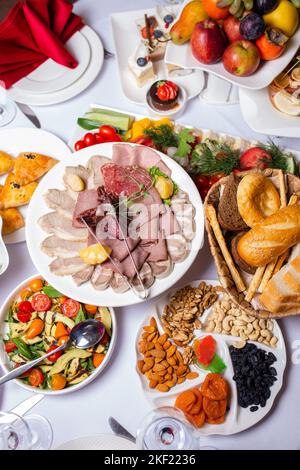 Blick von oben auf eine Vielzahl von Snacks vom Buffet im Hotel. Aufschnitt, verschiedene Käse- und Nussauswahl Stockfoto