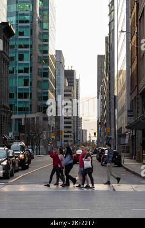 Ottawa, Kanada - 5. November 2022: Menschen überqueren Straße in der Innenstadt. Blick auf die Stadt mit Verkehr auf der Straße. Crosswalk Stockfoto