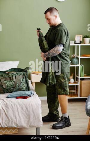 Seitenansicht Porträt eines Militärveteranen mit prothetischen Beinen und Armeeuniform Stockfoto