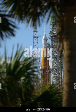 Kennedy Space Center, Vereinigte Staaten von Amerika. 14. November 2022. Die NASA-Rakete Artemis I Space Launch System mit der Orion-Sonde an Bord, die durch Palmetto-Bäume betrachtet wird, während sie auf dem Launch Complex 39B im Kennedy Space Center, 14. November 2022, in Cape Canaveral, Florida, vorbereitet wird. Nach mehreren gescheiterten Versuchen wird der Test für unbemundete Flüge im November 16. erwartet. Quelle: Bill Ingalls/NASA/Alamy Live News Stockfoto