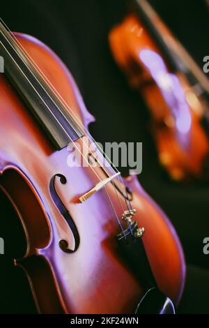 Detailansicht von zwei Violinen auf einigen Stühlen. Stockfoto