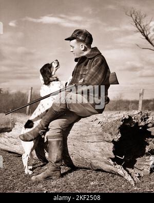 1930S 1940S MANN HUNTER TRÄGT KARO JACKE CAP HÄLT SCHROTFLINTE SITZT AUF HOHL LOG IM GESPRÄCH MIT SEINEM SPRINGER SPANIEL HUND - G2779 HAR001 HARS LÄNDLICHE NATUR KOPIEREN RAUM FREUNDSCHAFT VOLLZEIT PERSONEN FÜRSORGE MÄNNER HAUSTIERE JÄGER KARIERTE B&W JAGEN RUHENDES GLÜCK SÄUGETIERE ABENTEUER SEINE FREIZEIT LOG ECKZÄHNE LOW-ANGLE ERHOLUNG HERBST SAISON SPRINGER TO POOCH VERBINDUNG HOHL WOLLENEN HUNDE KOOPERATION FEUERWAFFE SCHUSSWAFFENJÄGER SÄUGETIERE MITTLEREN ERWACHSENEN MANN SCHROTFLINTEN ZWEISAMKEIT HERBSTLICHE VOGEL HUND SCHWARZ UND WEISS KAUKASISCHEN ETHNIE HERBST LAUB HAR001 JAGD HUND ALTMODISCH Stockfoto