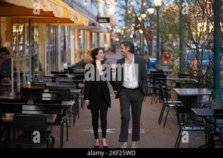 Romantische Fotos eines Paares, das in einer Innenstadt mit Straßenlaternen und Autos im Hintergrund für ein Date unterwegs war. Stockfoto