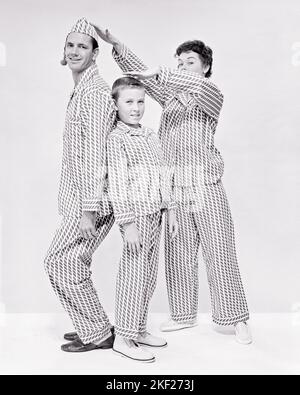 1950S GOOFY FAMILIENPORTRAIT VON 3 ALLE TRAGEN PYJAMAS BLICK AUF KAMERA VATER MUTTER SOHN MESSEN HÖHE SOHN RÜCKEN-AN-RÜCKEN VATER - J837 HAR001 HARS MÜTTER ALTE ZEIT ÜBERRASCHUNG NOSTALGIE ALTE MODE 1 JUGENDLICHE KOMMUNIKATION TEAMARBEIT SÖHNE ZUFRIEDEN FAMILIEN FREUDE LIFESTYLE FRAUEN VERHEIRATET STUDIO SCHUSS EHEGATTEN EHEMÄNNER GESUNDHEIT HEIM LEBEN KOPIEREN RAUM FREUNDSCHAFT GANZKÖRPERFRAUEN PERSONEN MÄNNER VERTRAUEN VÄTER S&W PARTNER AUGENKONTAKT TRÄUME GLÜCK FRÖHLICHE VÄTER STOLZ AUF LÄCHELN VERBINDUNG KONZEPTIONELL FREUDIG STILVOLLE RÜCKEN-ZU-RÜCKEN WACHSTUM JUGENDLICHE MITTLEREN ERWACHSENEN MITTLEREN ERWACHSENEN MANN MITTLEREN ERWACHSENEN FRAU MÜTTER VOR TEENAGER Stockfoto