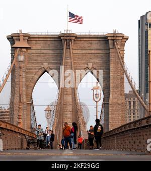New York City, USA - 18. September 2022: Männer und Frauen gehen auf der Brooklyn Bridge spazieren und fotografieren Stockfoto