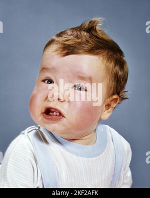 1960S BABY JUNGE MACHT LUSTIG GESICHTSAUSDRUCK BLICK AUF DIE KAMERA - KB4692 HAR001 HARS HOME LEBEN KOMMUNIKATION KOPIE RAUM MÄNNER AUSDRÜCKE TRAURIGKEIT AUGENKONTAKT HUMORVOLLER KOPF UND SCHULTERN BEUNRUHIGTE MENSCHEN BABYS BABY JUNGE KOMMUNIZIEREN JUGENDLICHE ZWEI ZÄHNE KAUKASISCHE ETHNIE HAR001 ALTMODISCH Stockfoto