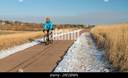 Winternachmittag auf einem Radweg mit einem älteren Radler auf einem Schotterrad - Cathy Fromme-Naturgebiet in Fort Collins, Colorado Stockfoto