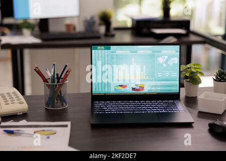 Laptop-Computer mit Grafiken und Diagrammen, Business-Accounting-Analyse. Office mit Datenwachstumsdiagrammen auf tragbaren Geräten, in denen niemand arbeitet, Statistikkonzept. Stockfoto