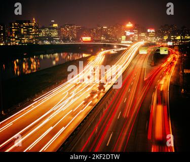 1960S 1970S NACHTAUTOAMPELN AUF DEM SCHUYLKILL EXPRESSWAY MIT SKYLINE DER INNENSTADT IM HINTERGRUND PHILADELPHIA PA USA - KP1450 HAR001 HARS OPPORTUNITY-SCHEINWERFER COMMONWEALTH-KONZEPT BEWEGUNGSUNSCHÄRFE KONZEPTUELLE RÜCKLEUCHTEN AUTOMOBILE KEYSTONE STATE VEHICLES SYMBOLISCHE KONZEPTE NÄCHTLICHE STADT BRÜDERLICHER LIEBE EXPRESSWAY HAR001 ALTMODISCHE DARSTELLUNG Stockfoto