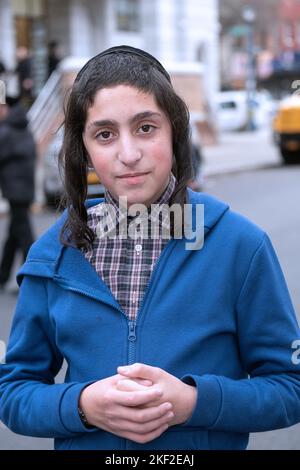 Posierte Porträt eines orthodoxen jüdischen Burschen mit langem Peyot. In Brooklyn, New York. Stockfoto