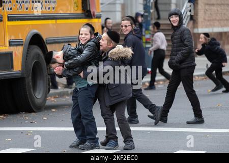 Orthodoxe jüdische Jungen mit langem Peyot haben Spaß in der Pause außerhalb ihrer Schule. In Brooklyn, New York. Stockfoto