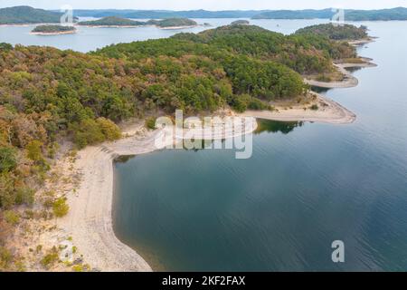 Luftaufnahme der Landschaft der Wasseroberfläche des Broken Bow Lake, Oklahoma, USA. Herbstlandschaft der Küstenlinie mit Wald am Ufer. Stockfoto