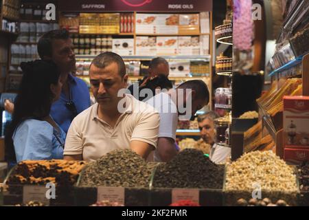 Istanbul, Türkei - 1 2022. Oktober: Einkäufer und Verkäufer bei einer bunten Gewürzlader-Ausstellung auf dem Gewürzbasar in Istanbul, Türkei. Stockfoto