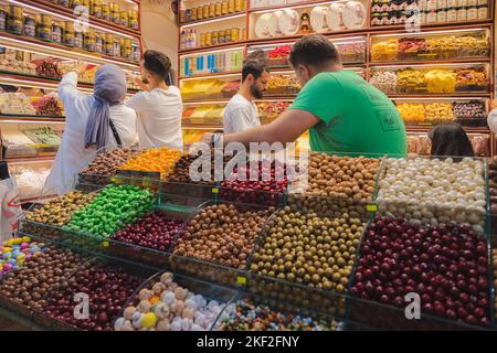 Istanbul, Türkei - 1 2022. Oktober: Shopper und Händler in einem bunten Geschäft mit Süßigkeiten, türkischem Genuss und Trockenfrüchten auf dem berühmten Markt Gr Stockfoto