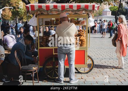 Istanbul, Türkei - 1 2022. Oktober: Ein traditioneller türkischer Straßenhändler im Touristenviertel Sultanahmet verkauft Brezeln aus einem Imbißstand im IS Stockfoto