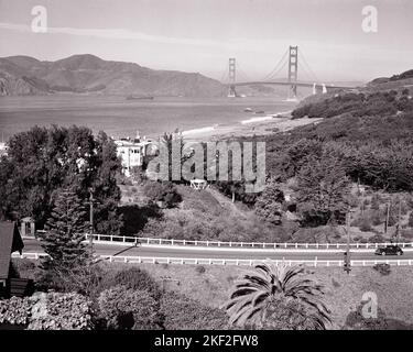 1940S DIE GOLDEN GATE BRIDGE UND DIE MEERENGE, DIE DIE BUCHT MIT DEM OZEAN VERBINDET VOM PRESIDIO-GELÄNDE AUS GESEHEN SAN FRANCISCO CA USA - R13582 PUN001 SCHWARZ-WEISS-BRÜCKEN ÜBERSPANNEN DAS GOLDEN GATE VERBINDET DIE ALTMODISCHE PRESIDIO STRAIT Stockfoto