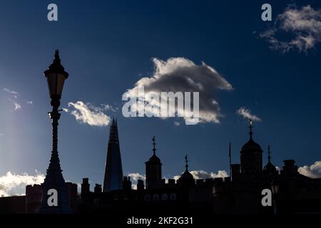 Ein beeindruckender Blick auf den Tower of London.Ein Silhouettenbild mit den Turmtürmen, klassischen Lampenpfosten und dem Shard vor einem dunkelblauen Himmel.atemberaubend Stockfoto