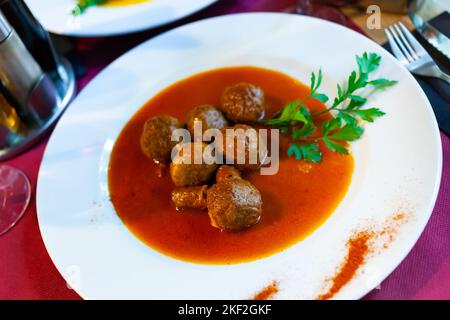 Rauchige spanische Fleischbällchen in Tomatensauce mit Würstchen Stockfoto
