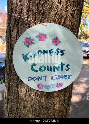 Auf einem Baum in einer Wohnstraße im Stadtteil Kensington in Brooklyn, New York, darf kein Wurfschild mit einer doppelten Botschaft stehen. Stockfoto