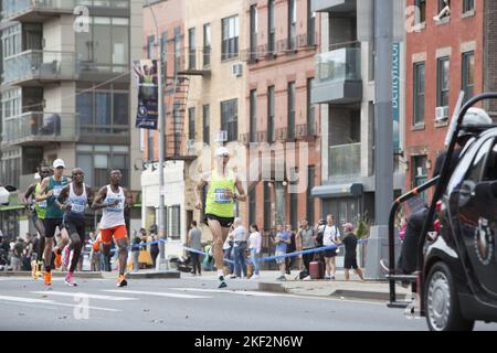 2022 TCS New York City Marathon-Läufer fahren auf der 4. Avenue durch Park Slope Brooklyn während der ersten Etappe des Rennens. Professionelle männliche Spitzenläufer, darunter Evans Chebet aus Kenia, der das Rennen schließlich gewann. Zuvor gewann er auch den Boston-Marathon 2022. Stockfoto