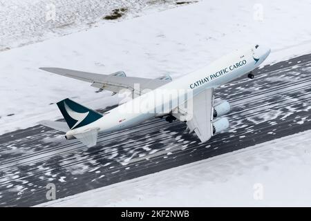 Cathay Pacific Cargo Boeing 747-8F-Flugzeuge starten nach einem Schneefall vom Flughafen Anchorage aus. Flugzeug des Frachters Cathay Pacific Cargo 747 nimmt ab. Stockfoto