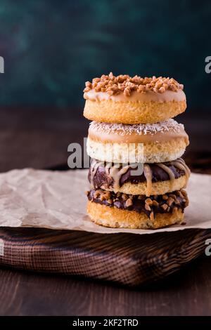 Eine Nahaufnahme eines Stapels hausgemachter Donuts mit verschiedenen Belägen. Stockfoto