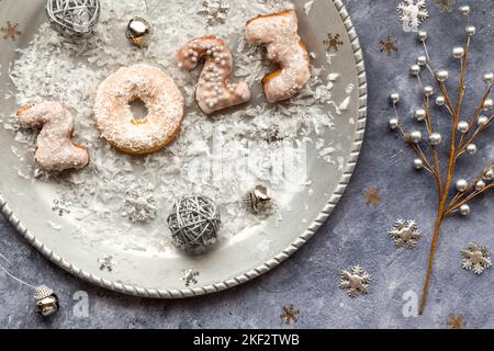 Eine silberne Platte mit 2023 Donuts, um das neue Jahr zu feiern. Stockfoto