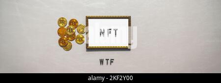 NFT Cryto Digital Art Text in goldenem Rahmen und Krytowährung auf silbernem Banner-Hintergrund. NFT WTF-Konzept für Zusammenbruch, Absturz und Verwirrung Stockfoto