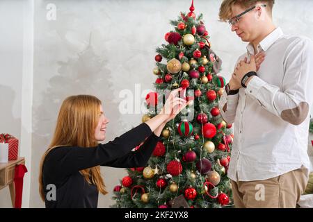 Peinlicher Moment. Junge Frau hält Box mit Verlobungsring und macht Heiratsantrag an ihren Freund. Stockfoto