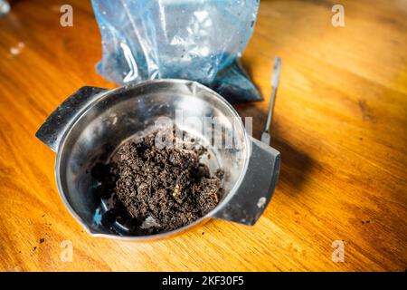 Durchführung eines Bodentests in einem Heimlabor. Boden auf einem Tisch. Brauner Schmutz auf einem Feld. Erdhaufen und Kompost Stockfoto