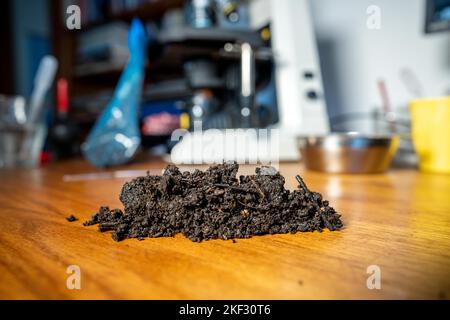 Durchführung eines Bodentests in einem Heimlabor. Boden auf einem Tisch. Brauner Schmutz auf einem Feld. Erdhaufen und Kompost Stockfoto