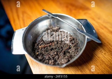Durchführung eines Bodentests in einem Heimlabor. Boden auf einem Tisch. Brauner Schmutz auf einem Feld. Erdhaufen und Kompost Stockfoto