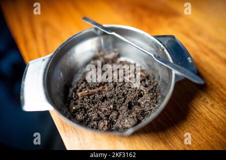 Durchführung eines Bodentests in einem Heimlabor. Boden auf einem Tisch. Brauner Schmutz auf einem Feld. Erdhaufen und Kompost Stockfoto
