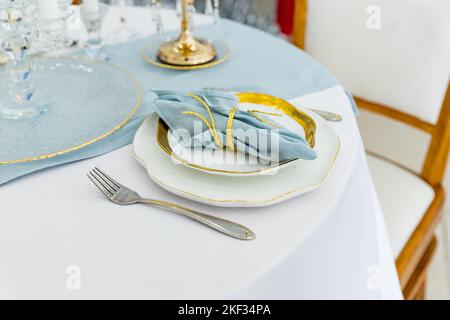 Luxuriöse Tischkulisse im Marinestil mit Kerzen, Muscheln. Tisch serviert für Verlobung, Hochzeit, romantisches Abendessen oder festliche Veranstaltung. Stockfoto