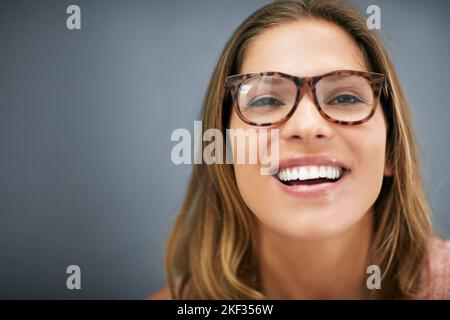 Wie gefällt Ihnen meine neue Spezifikation? Verkürztes Studioporträt einer attraktiven jungen Frau mit Brille. Stockfoto