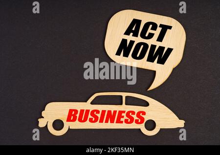 Geschäfts- und Finanzkonzept. Auf schwarzem Hintergrund ein Auto mit der Aufschrift Business, darüber ein Schild mit der Aufschrift - Act Now Stockfoto