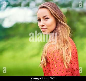 Ich kann mir keinen besseren Weg vorstellen, den Tag zu verbringen. Beschnittenes Porträt einer jungen Frau, die im Freien steht. Stockfoto