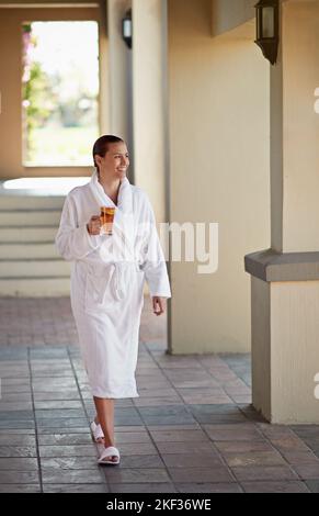 Flucht aus dem Alltag. Eine junge Frau trinkt einen Eistee im Day Spa. Stockfoto