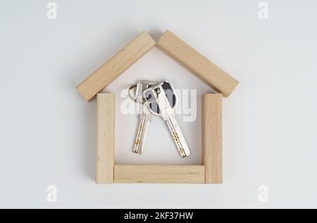 Geschäftskonzept. Auf weißem Hintergrund ein kleines Haus aus Holzbrettern, Schlüssel innen.