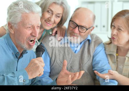 Zwei ältere Paare singen Karaoke Stockfoto