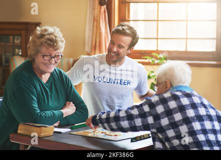 Es fühlt sich gut an, Gutes zu tun. Ein Freiwilliger, der mit Senioren in einem Altersheim arbeitet. Stockfoto