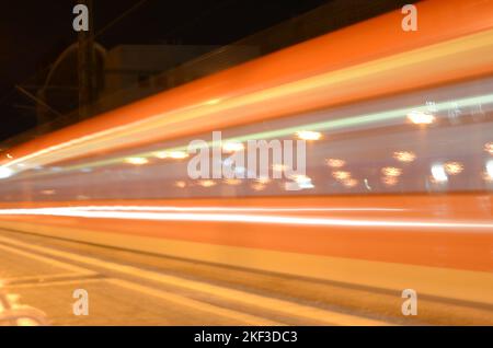 Zug, der mit hoher Geschwindigkeit durch einen Bahnhof fährt Stockfoto